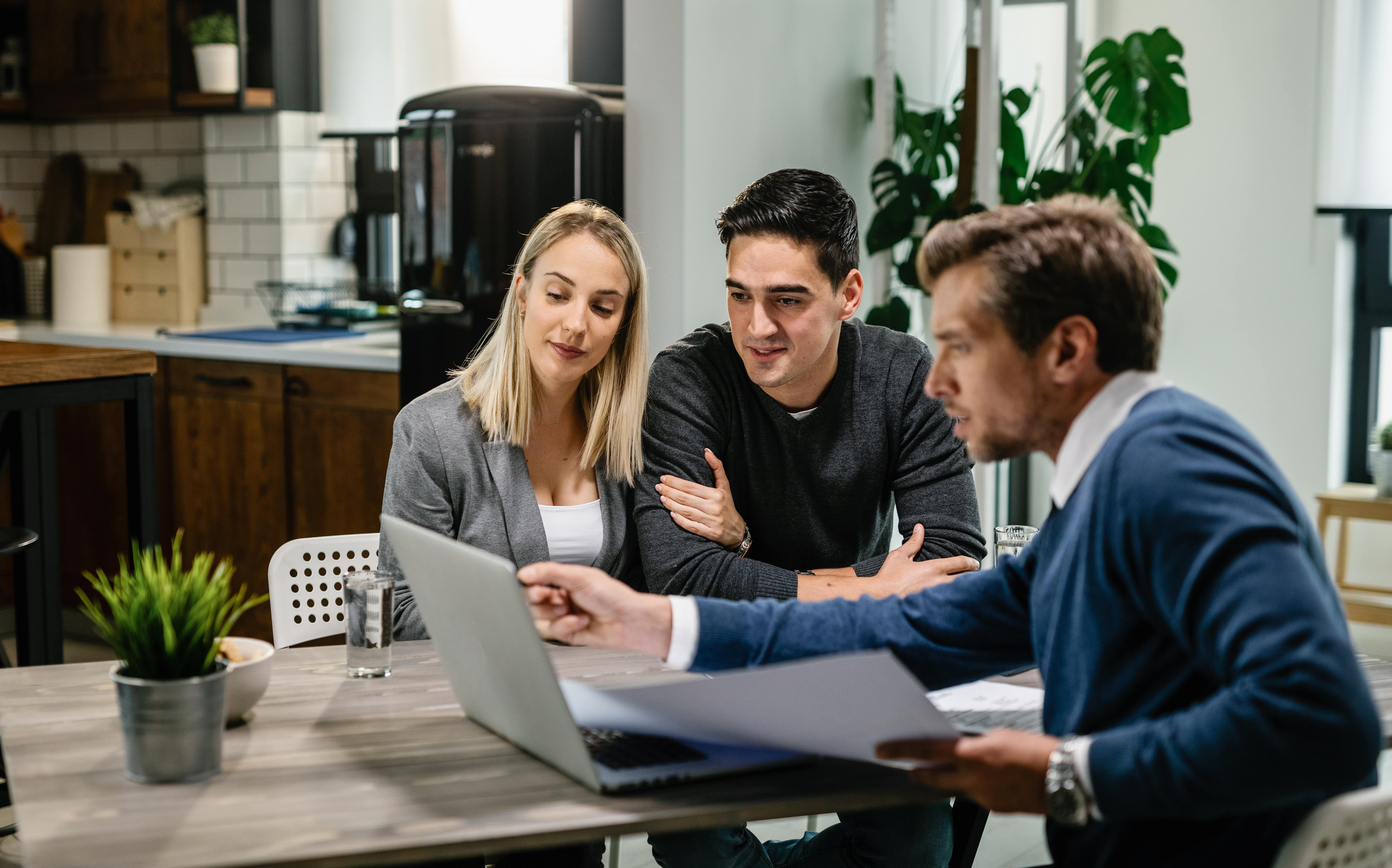 young-couple-real-estate-agent-using-laptop-while-going-through-housing-plan-meeting (1)-min RECAMP | Insurance Agent Coaching Training